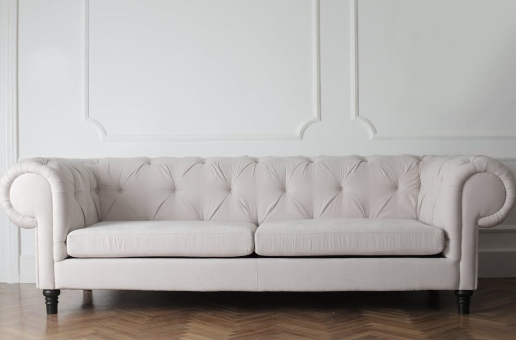 Luxurious white sofa in a modern minimalist interior with wooden flooring.